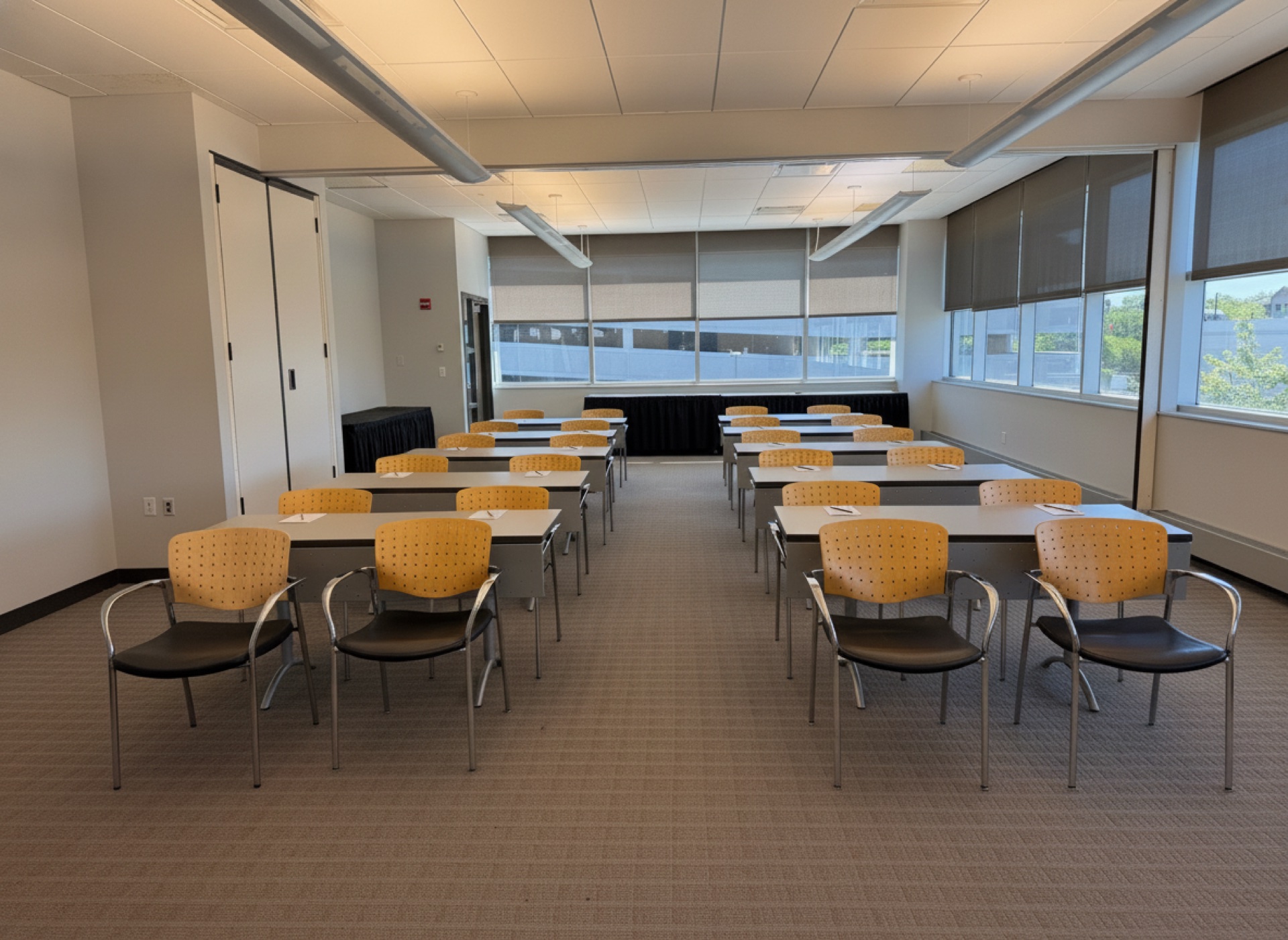 A seminar room with rows of tables facing a stage