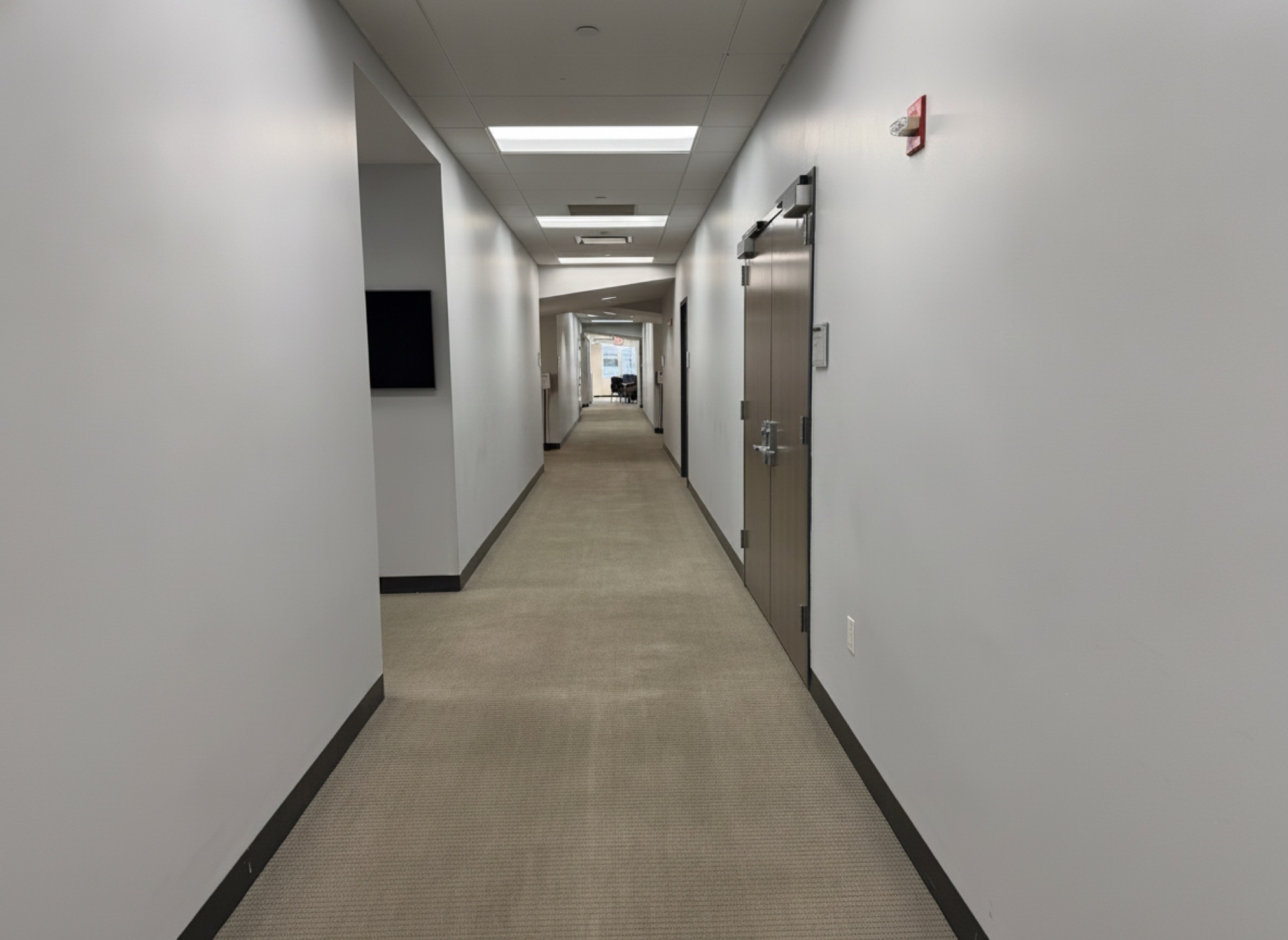 A carpeted corridor connecting the rooms